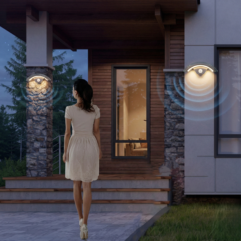 Orbit, l'applique murale d'extérieur à détecteur de mouvement s'allume automatiquement lorsque la femme monte les marches