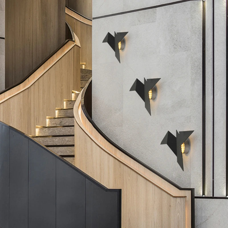 Appliques murales LED oiseaux noirs installées le long d’un escalier moderne