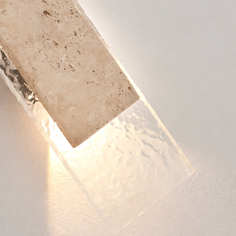 Détail de la pierre naturelle de l’applique murale Petra-Linéaire avec verre texturé et éclairage chaleureux.