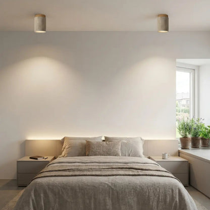 Plafonniers en pierre de travertin allumés au plafond d'une chambre à coucher à la décoration épurée et naturelle