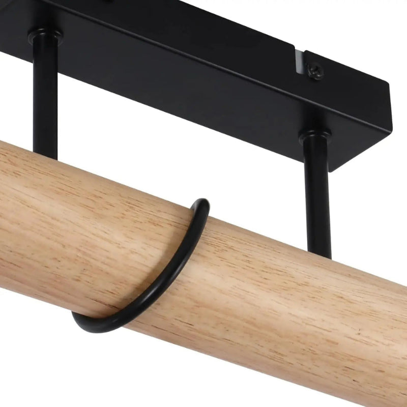 Gros plan sur la fixation plafond en acier noir mat et la barre cylindrique en bois massif du luminaire