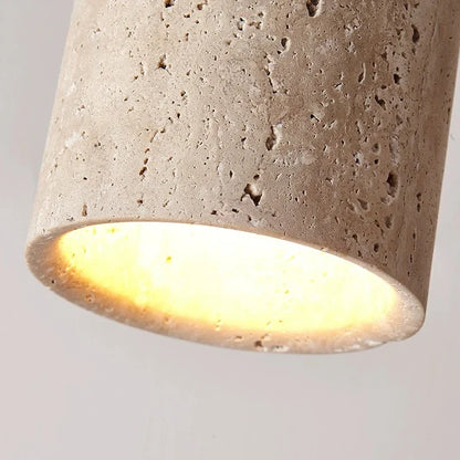 Gros plan sur la texture poreuse de la pierre de travertin beige et le faisceau lumineux chaleureux du spot