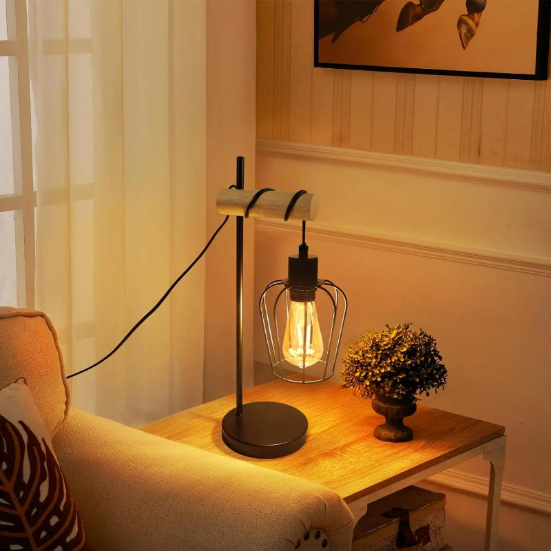 Petite lampe d'appoint industrielle en métal et bois posée sur un meuble en bois près d'un canapé