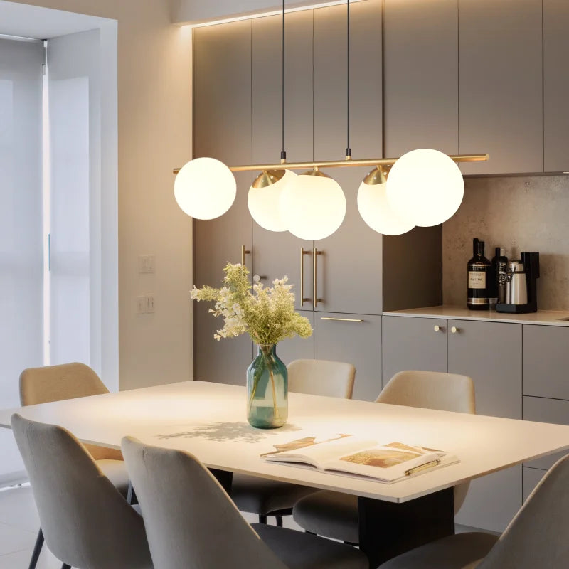 Suspension moderne à plusieurs globes lumineux installée au-dessus d'une table de repas dans une cuisine ouverte