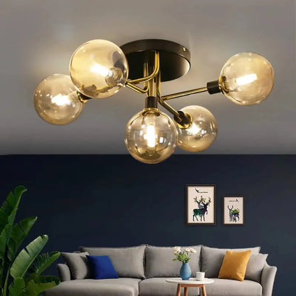 Plafonnier à globes ambrés et branches dorées au plafond d'un salon avec mur d'accent bleu nuit