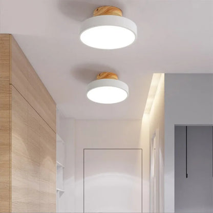 Plafonniers LED ronds blancs avec finition bois naturel dans un couloir lumineux