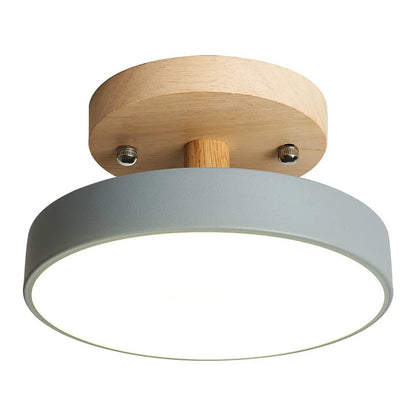 Gros plan d'un plafonnier LED rond gris avec support en bois naturel et diffuseur lumineux