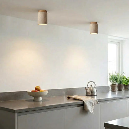 Spots de plafond en pierre naturelle illuminant un plan de travail et un pan de mur blanc dans une cuisine