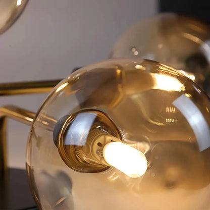 Zoom sur les abat-jours sphériques en verre teinté ambré diffusant une lumière chaude